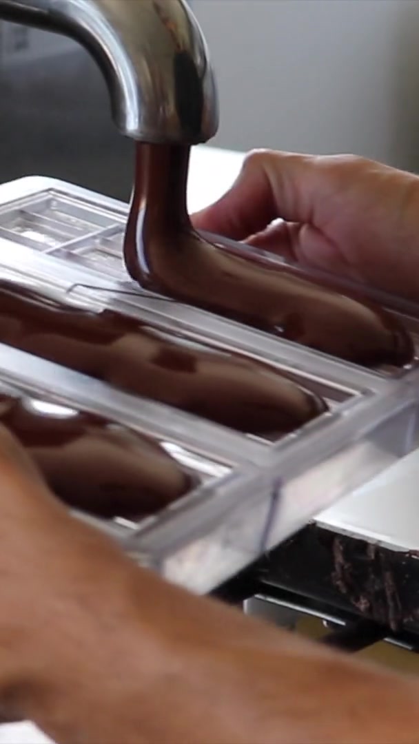 Moldeado de tabletas de chocolate en el obrador de Essenzo Cacao